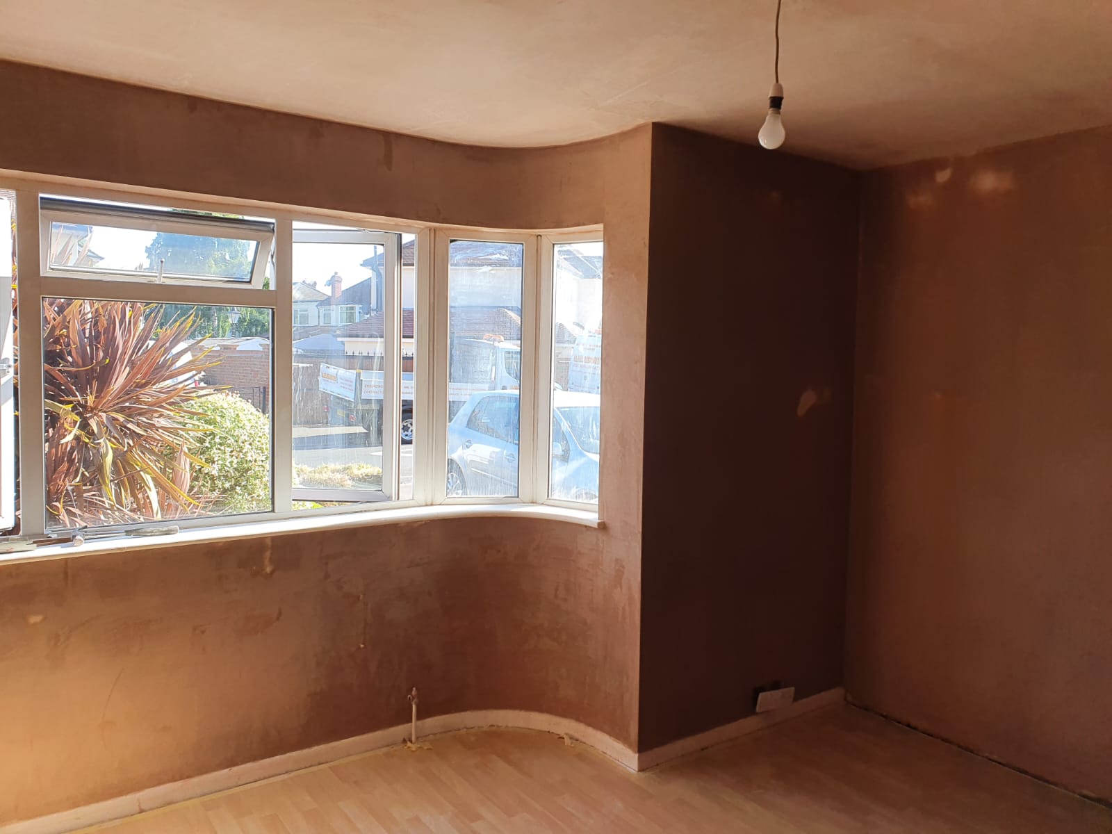 Bay-window living room re-skimmed in fresh pink plaster