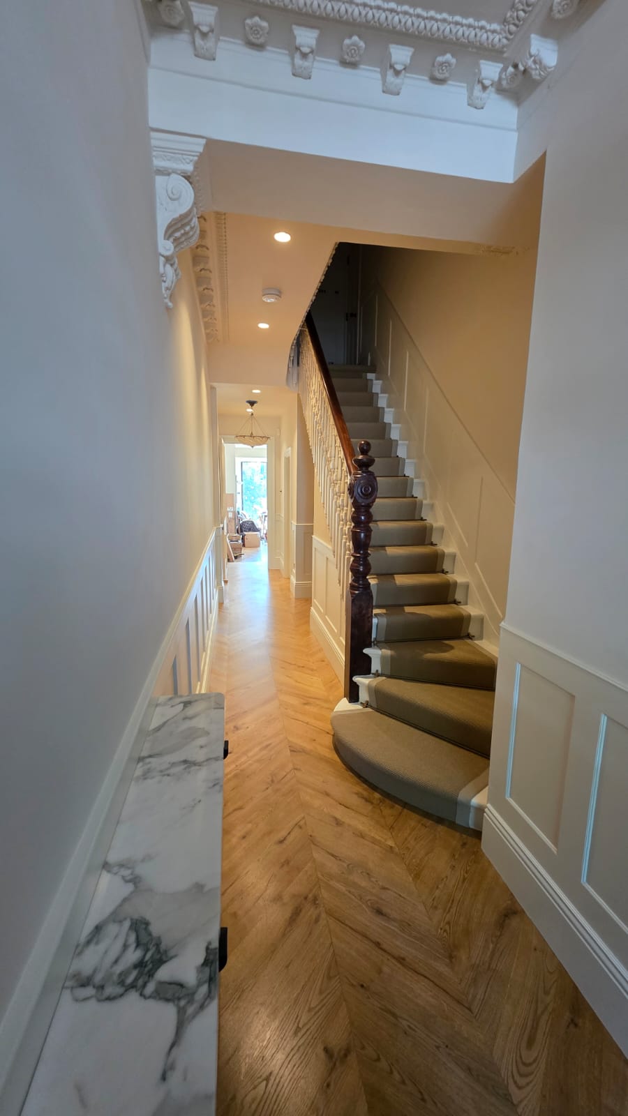 Restored staircase, cornice and marble-look hallway in a full house renovation