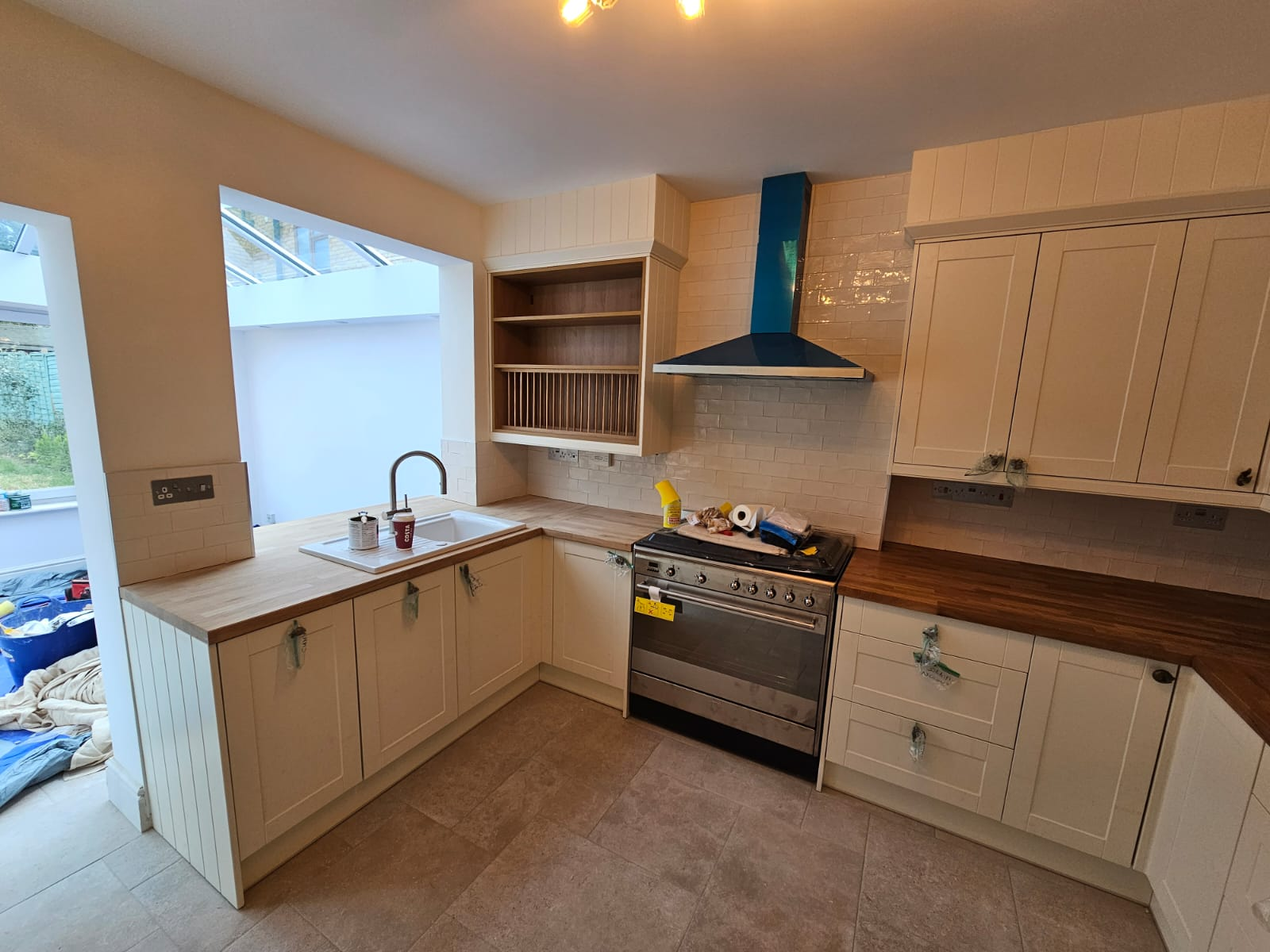 Renovated kitchen with cream shaker cabinets, tiled splashback and range cooker fitted during a full house renovation